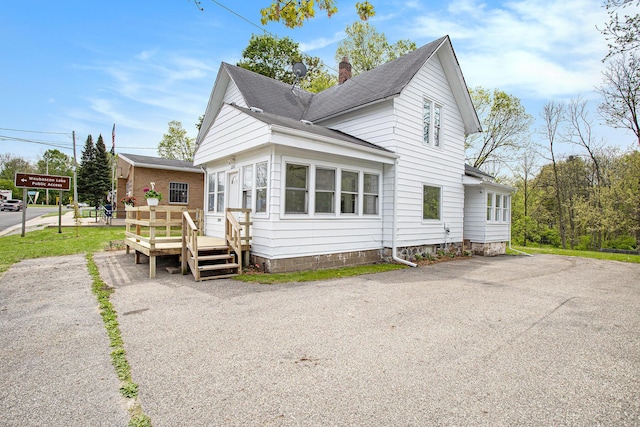 22121 Bedford Rd N, Battle Creek, MI 49017 - view of front of property featuring a wooden deck, a chimney, and roof with shingles