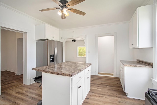 22121 Bedford Rd N, Battle Creek, MI 49017 - kitchen with stainless steel refrigerator with ice dispenser, light wood-style floors, white cabinets, ceiling fan, and ornamental molding