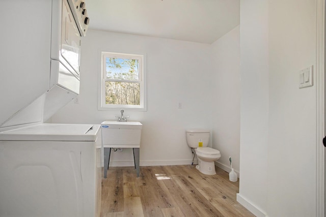 22121 Bedford Rd N, Battle Creek, MI 49017 - bathroom featuring stacked washer and clothes dryer and wood finished floors