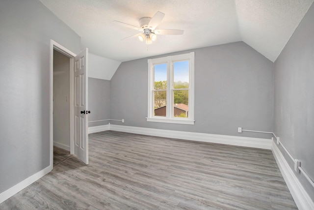 22121 Bedford Rd N, Battle Creek, MI 49017 - additional living space with vaulted ceiling, ceiling fan, a textured ceiling, and wood finished floors