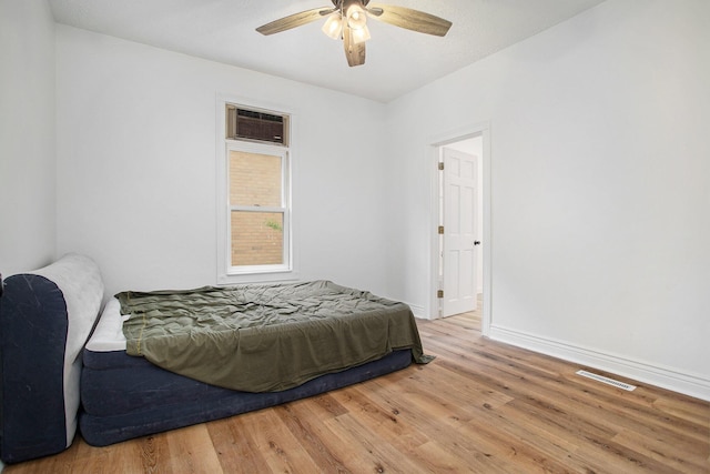 22121 Bedford Rd N, Battle Creek, MI 49017 - bedroom with wood finished floors, ceiling fan, and a wall mounted AC
