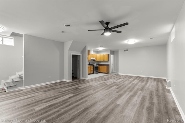 7115 Steadman St, Dearborn, MI 48126 - unfurnished living room featuring light wood finished floors, a ceiling fan, and stairs