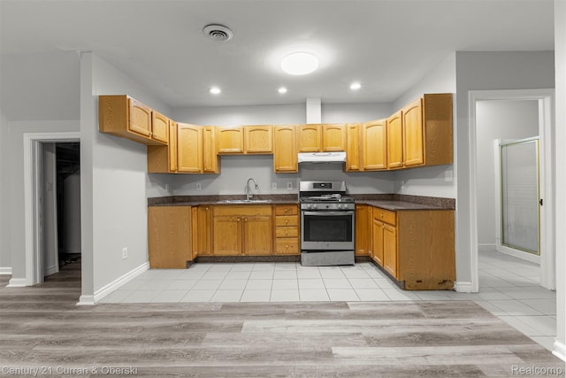 7115 Steadman St, Dearborn, MI 48126 - kitchen with gas range, under cabinet range hood, dark countertops, light tile patterned floors, and recessed lighting