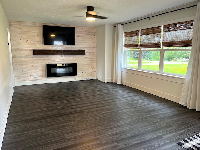 838 Meadow Dr, Traverse City, MI 49685 - unfurnished living room featuring dark wood-style floors, a fireplace, a ceiling fan, and a textured ceiling