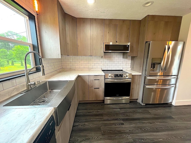 838 Meadow Dr, Traverse City, MI 49685 - kitchen with appliances with stainless steel finishes, dark wood-style floors, light countertops, decorative backsplash, and a textured ceiling