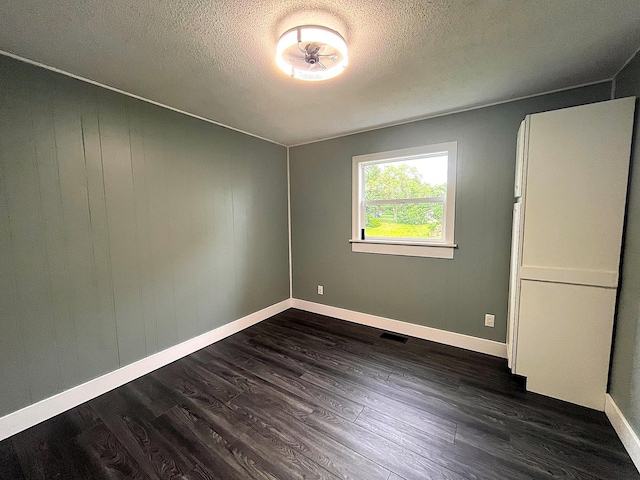 838 Meadow Dr, Traverse City, MI 49685 - unfurnished room featuring dark wood-style floors and a textured ceiling