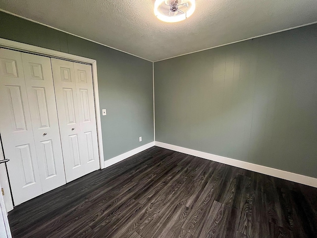 838 Meadow Dr, Traverse City, MI 49685 - unfurnished bedroom with dark wood-style floors, a textured ceiling, and a closet