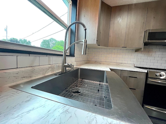838 Meadow Dr, Traverse City, MI 49685 - kitchen with stainless steel appliances, backsplash, marble look tile flooring, modern cabinets, and light stone countertops