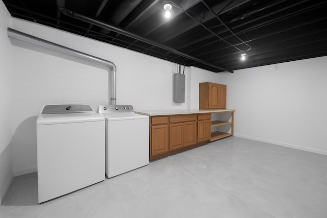 838 Meadow Dr, Traverse City, MI 49685 - laundry area with cabinet space, washing machine and dryer, electric panel, and concrete block wall