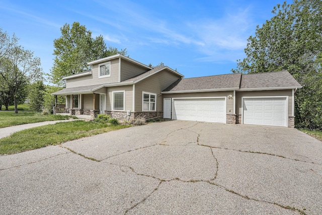 5643 Ivanrest Ave SW, Wyoming, MI 49418 - view of front of home with stone siding, a garage, driveway, covered porch, and a shingled roof