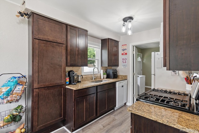 14634 Mcguire St, Taylor, MI 48180 - kitchen featuring white dishwasher, dark brown cabinets, light wood-style floors, light stone counters, and gas range