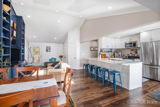 11986 Reyburn Dr NE, Sparta, MI 49345 - dining space featuring vaulted ceiling, dark wood-style flooring, and recessed lighting