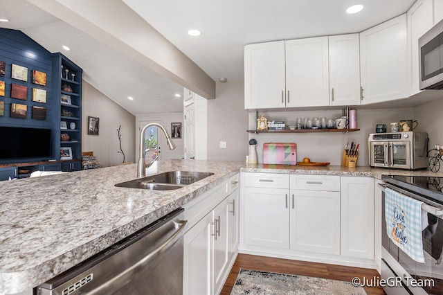 11986 Reyburn Dr NE, Sparta, MI 49345 - kitchen with stainless steel appliances, lofted ceiling, wood finished floors, white cabinets, and light stone counters