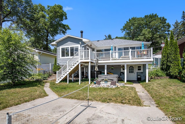 11986 Reyburn Dr NE, Sparta, MI 49345 - back of property featuring a hot tub, a deck, and stairs
