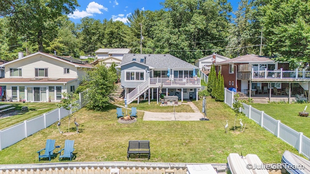 11986 Reyburn Dr NE, Sparta, MI 49345 - view of front of house featuring an outdoor fire pit, a wooden deck, stairway, a patio area, and a fenced backyard