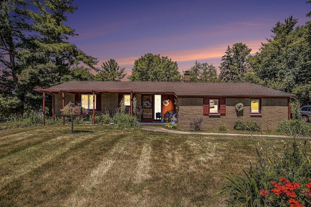 3706 Northview Dr, Kalamazoo, MI 49004 - ranch-style house with brick siding, a porch, a yard, and a chimney