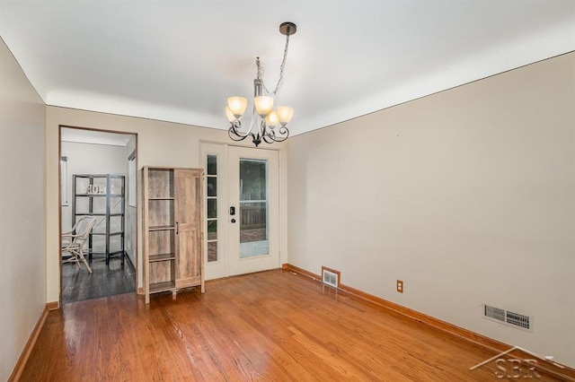 2220 Mershon St, Saginaw, MI 48602 - spare room with a chandelier, wood finished floors, and french doors