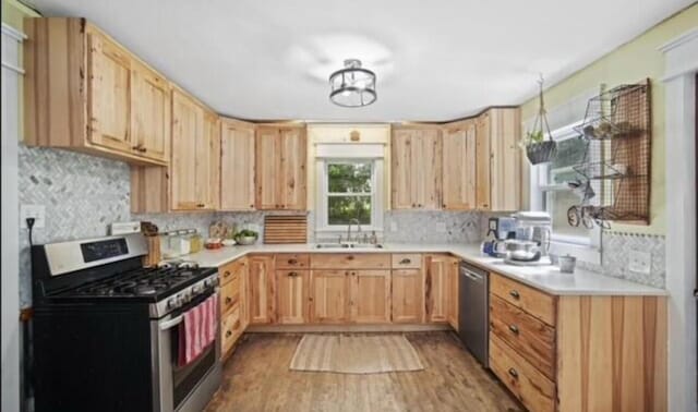 519 Hanover St, Concord, MI 49237 - kitchen featuring appliances with stainless steel finishes, light brown cabinets, light wood-style flooring, light countertops, and backsplash
