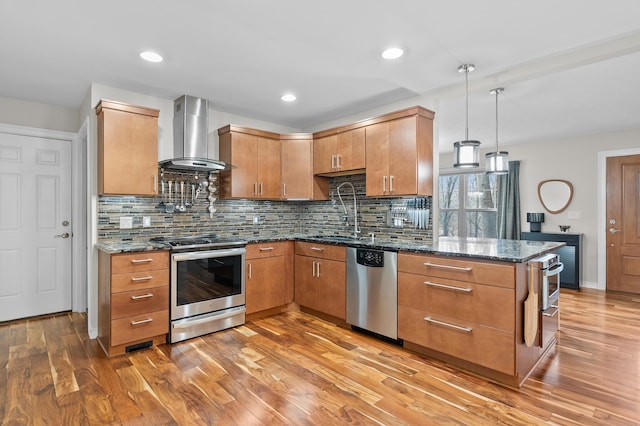 5643 E C Ave, Richland, MI 49083 - kitchen featuring wall chimney exhaust hood, stainless steel appliances, light wood-style floors, backsplash, and dark stone counters