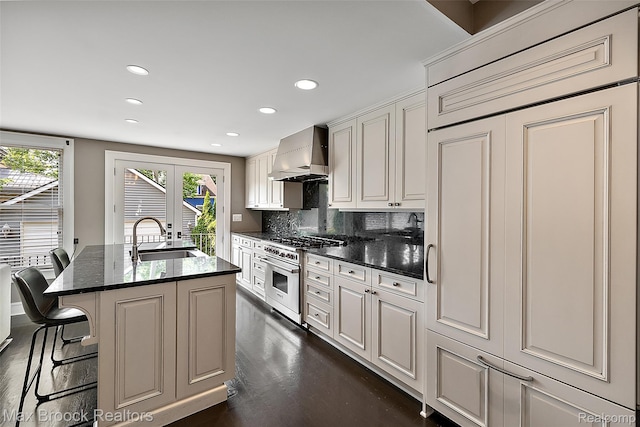 504 Landon St, Birmingham, MI 48009 - kitchen with high quality appliances, wall chimney range hood, recessed lighting, a kitchen island with sink, and tasteful backsplash