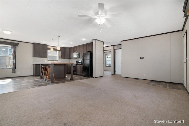 947 Redwood Dr, Hastings, MI 49058 - kitchen with freestanding refrigerator, electric stove, dark brown cabinets, light countertops, and stainless steel microwave