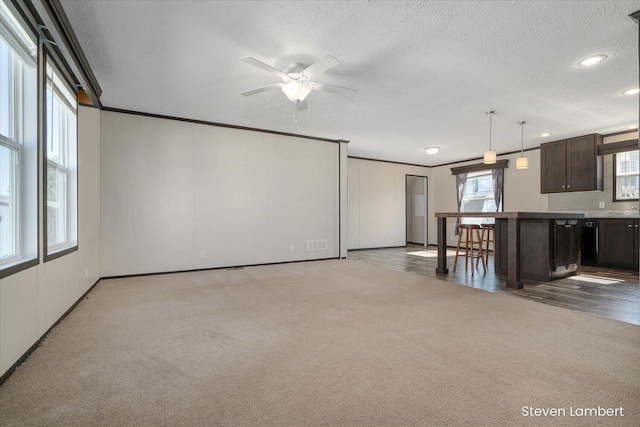 947 Redwood Dr, Hastings, MI 49058 - unfurnished living room with carpet flooring, ceiling fan, a textured ceiling, ornamental molding, and recessed lighting