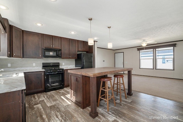 947 Redwood Dr, Hastings, MI 49058 - kitchen featuring black appliances, dark wood finished floors, dark brown cabinets, and recessed lighting