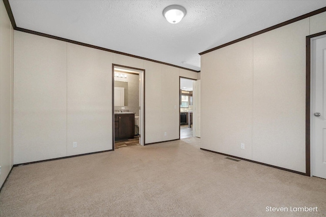 947 Redwood Dr, Hastings, MI 49058 - unfurnished bedroom with ornamental molding, a textured ceiling, light colored carpet, and ensuite bath
