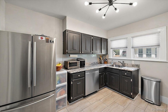 129 E Maryland Ave, Royal Oak, MI 48067 - kitchen featuring stainless steel appliances, a chandelier, light stone countertops, light tile patterned flooring, and dark cabinetry