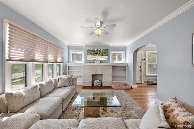 129 E Maryland Ave, Royal Oak, MI 48067 - living room with arched walkways, a ceiling fan, ornamental molding, wood finished floors, and a fireplace