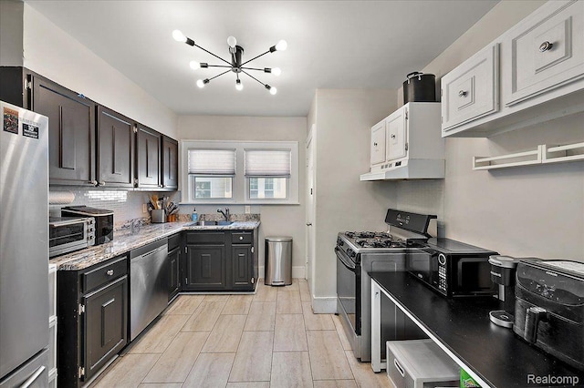 129 E Maryland Ave, Royal Oak, MI 48067 - kitchen featuring black appliances, under cabinet range hood, a chandelier, tasteful backsplash, and light stone countertops