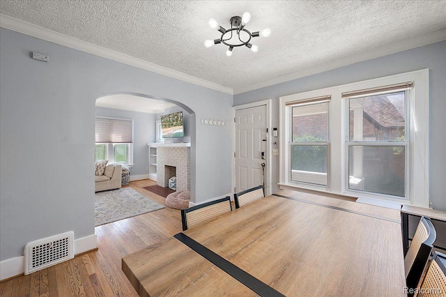 129 E Maryland Ave, Royal Oak, MI 48067 - foyer entrance with a chandelier, arched walkways, crown molding, wood finished floors, and a fireplace