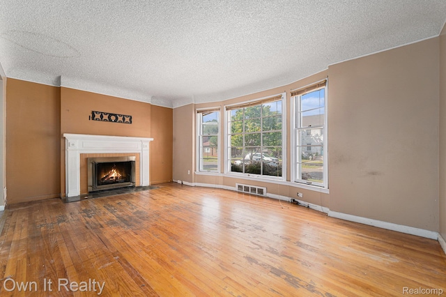 74 Chestnut St, River Rouge, MI 48218 - unfurnished living room with a textured ceiling, hardwood / wood-style flooring, and a fireplace with flush hearth