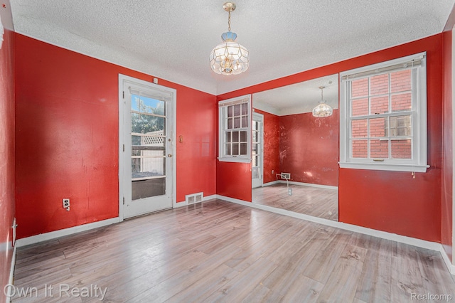 74 Chestnut St, River Rouge, MI 48218 - unfurnished room featuring a chandelier, wood finished floors, and a textured ceiling