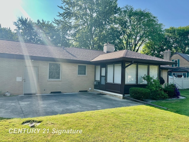 1751 Lathrup Ave, Saginaw, MI 48638 - rear view of house with a lawn, brick siding, a chimney, roof with shingles, and a patio area