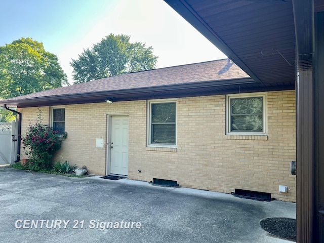 1751 Lathrup Ave, Saginaw, MI 48638 - rear view of house with brick siding, a shingled roof, and a patio area