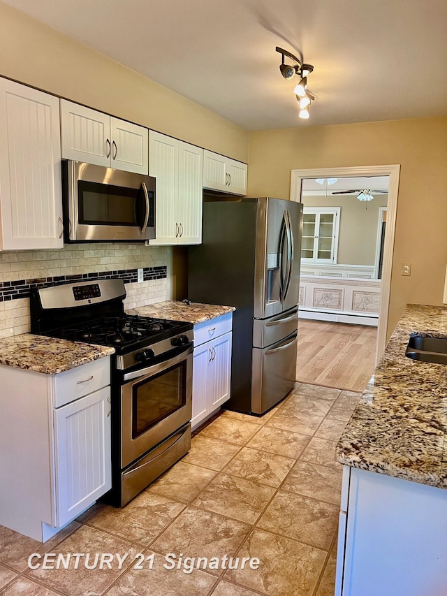 1751 Lathrup Ave, Saginaw, MI 48638 - kitchen with stainless steel appliances, tasteful backsplash, white cabinets, and a baseboard radiator