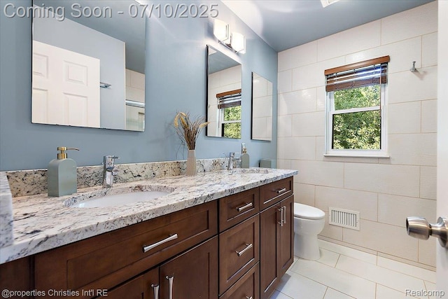25426 Lindenwood Ln, Southfield, MI 48033 - bathroom featuring double vanity, tile patterned flooring, healthy amount of natural light, and tile walls