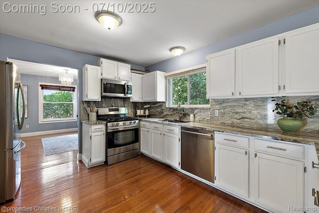 25426 Lindenwood Ln, Southfield, MI 48033 - kitchen featuring appliances with stainless steel finishes, white cabinetry, backsplash, and a chandelier