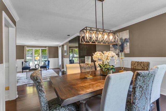 3800 Guest Rd, Jackson, MI 49203 - dining space featuring a chandelier, a wainscoted wall, a decorative wall, crown molding, and wood finished floors