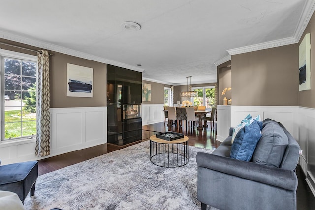 3800 Guest Rd, Jackson, MI 49203 - living area featuring dark wood-style flooring, ornamental molding, a decorative wall, a wainscoted wall, and a chandelier