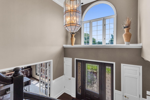 3800 Guest Rd, Jackson, MI 49203 - foyer entrance featuring a towering ceiling, a chandelier, and a wainscoted wall