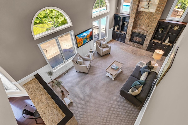 3800 Guest Rd, Jackson, MI 49203 - living room featuring a high ceiling, a brick fireplace, and built in features