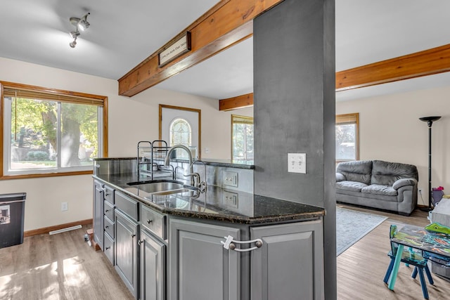 226 Briscoe Pl, Jackson, MI 49203 - kitchen featuring beam ceiling, light wood-style flooring, healthy amount of natural light, and dark stone counters