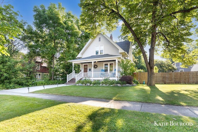 140 S Monroe St NE, Rockford, MI 49341 - view of front facade with covered porch, a chimney, and roof with shingles