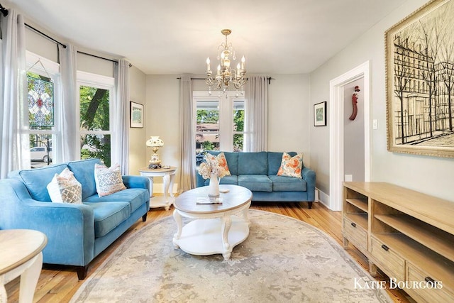 140 S Monroe St NE, Rockford, MI 49341 - living room featuring a chandelier, wood finished floors, and plenty of natural light