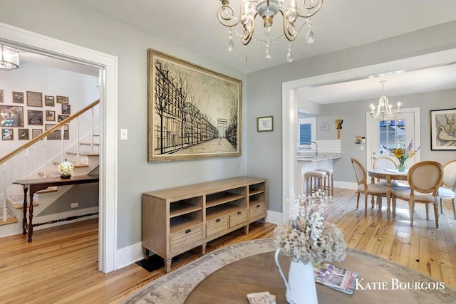 140 S Monroe St NE, Rockford, MI 49341 - dining area featuring a chandelier, wood-type flooring, and stairs