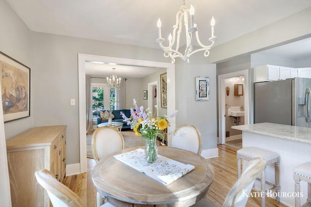 140 S Monroe St NE, Rockford, MI 49341 - dining space featuring a chandelier and light wood-style floors