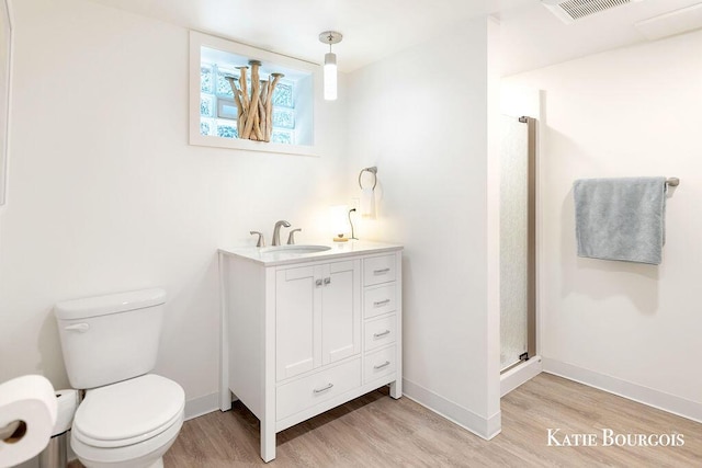 140 S Monroe St NE, Rockford, MI 49341 - bathroom featuring wood finished floors, vanity, and a stall shower