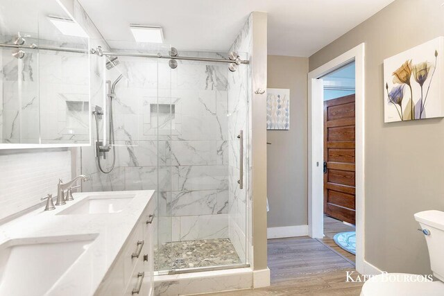 140 S Monroe St NE, Rockford, MI 49341 - full bath with a marble finish shower, wood finished floors, and double vanity